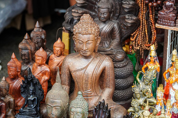 Intricate collection of wooden and metallic statues, showcasing detailed carvings of Buddha figures and other deities, capturing spiritual artistry and cultural craftsmanship.