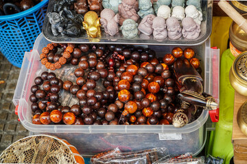 Assortment of spiritual items featuring stone statues, wooden beads, meditation accessories and other decorative objects creating a cultural ambiance and promoting mindfulness and inner peace.