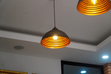 Fototapeta premium Illuminating the space with modern flair, these pendant lights cast a warm, inviting glow. Their unique design adds a touch of elegance, perfect for any contemporary interior space.