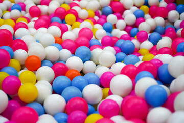 A vibrant array of colorful balls creates a playful and eye-catching background. The mix of white, pink, blue, yellow, and orange hues evokes feelings of fun and joy perfect for many projects.