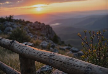 Fototapeta premium Scenic viewpoint overlooking hills at sunset with wooden railing and marker post
