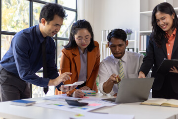 Business team working together, using laptop and documents with charts and graphs, analyzing financial data and discussing strategies for success.