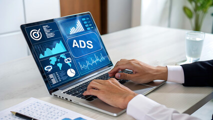 Modern marketer analyzing advertising performance metrics on laptop, optimizing digital marketing strategy for increased ROI and business growth success