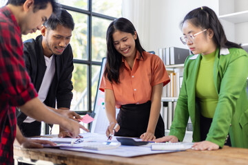 Startup business team analyzing documents at meeting table. Young entrepreneurs are reviewing documents and discussing business strategy during a meeting in a modern office space.