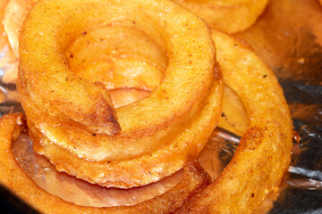 Close up of curly fries chips on foil cooked and ready to serve