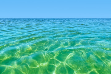 Bright and fresh seascape on a sunny day under a clear sky. Azure sea surface near the coastline.