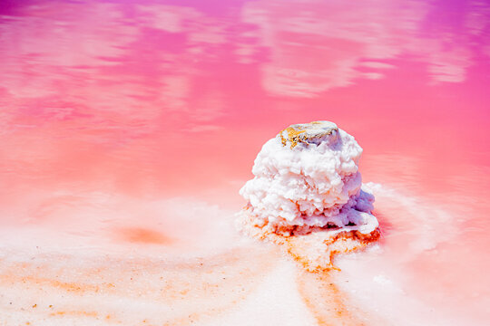 incredible beautiful natural phenomenon pink lake salt flats with soft pink water and white salt on the shore and pillars covered with salt, salt mining