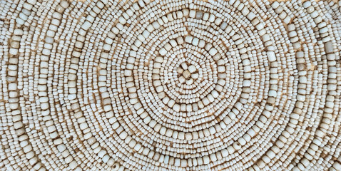 Naklejka premium Background of circular pattern on ivory beads, up close. Traditional handicraft of ivory beads with circular pattern for decoration.