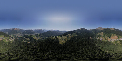 Super wide 360 angle aerial panorama of mountain slope with green meadows and pine tree divide with cloud obscuring half of the scenery. Picturesque colorful high altitude weather condition concept.