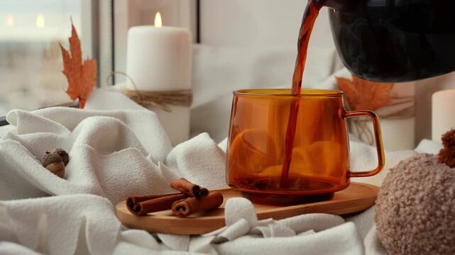 Pour coffee into cup Pumpkin spiced latte morning warming coffee. Fall Drinks for Halloween Thanksgiving Holiday beverage Autumn spicy cinnamon flavor seasonal hot drinking in cozy orange cup