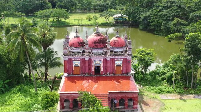 Barishal, Bangladesh - 22 August 2025: Aerial view of the Baitul Aman Jame Masjid Complex with its distinctive red domes and ornate facade, a serene landscape.