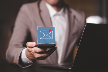 Businessman using email marketing tools on laptop and smartphone, sending newsletters and analyzing campaign performance to engage subscribers and grow business through personalized content