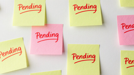 Sticky notes in multiple colors with pending labels covering wall surface