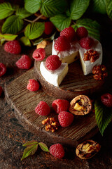 Camembert cheese with fresh raspberries and walnuts.