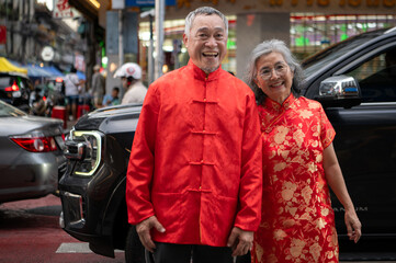 Fototapeta premium A happy senior couple strolls along a Chinatown in Bangkok, Thailand,