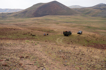 Rural Off-Road Adventure with Trucks and Campers in Volcanic Valley