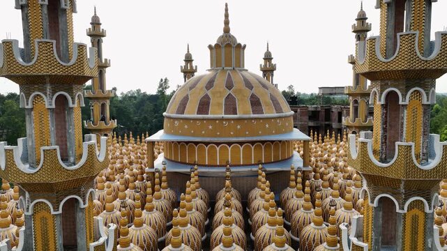 Tangail, Bangladesh - 22 August 2025: Aerial view of the golden-hued 201 Dome Mosque, its intricate domes and minarets creating a mesmerizing architectural tapestry.