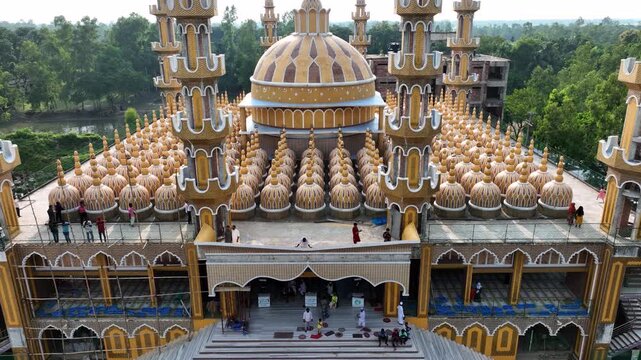 Tangail, Bangladesh - 22 August 2025: Aerial view of the 201 Dome Mosque's intricate architecture, a golden spectacle against the lush green backdrop.