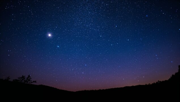 A clear starry night sky stretches above the dark mountain horizon, featuring countless bright stars and a glowing planet visible against deep blue and purple twilight tones