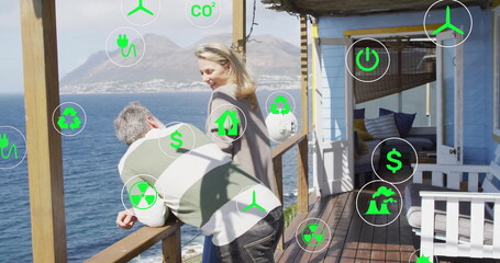 Leaning couple gazing at water on wooden deck railing at coastal cabin lounge with energy icons