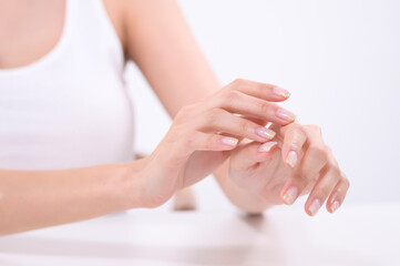 Fototapeta premium Woman Applying Skincare Product to Her Hand in a Bright and Clean Environment