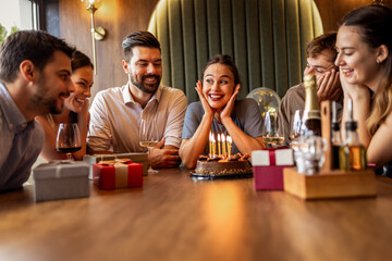 Birthday Girl Blowing Candles Surrounded by Friends