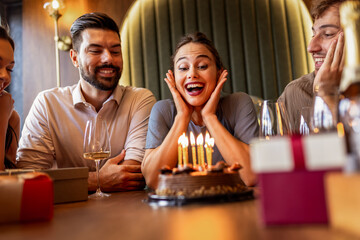 Birthday Girl Blowing Candles Surrounded by Friends