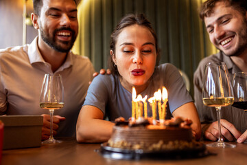 Birthday Girl Blowing Candles Surrounded by Friends
