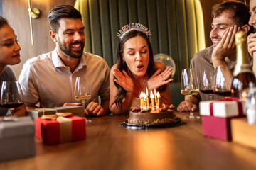 Birthday Girl Blowing Candles Surrounded by Friends