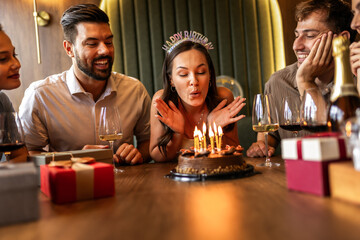 Birthday Girl Blowing Candles Surrounded by Friends