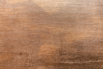 Textured brown surface with abstract patterns and gradients in natural lighting