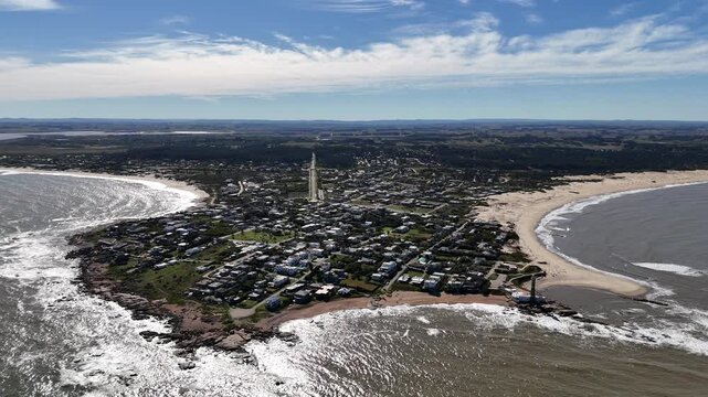 Aerial drone scene of lighthouse at touristic town with rocky and sandy shore. Faro de Jose Ignacio. Uruguay, Maldonado