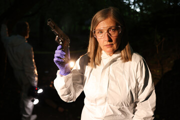 Forensic experts working at crime scene outdoors, selective focus