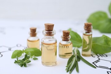 Different herbs and bottles of cosmetic products on paper with chemical formulas, closeup