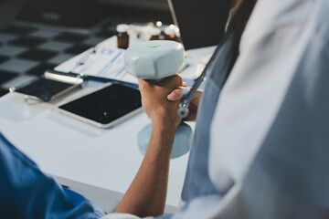 Person using hand weight with support of nurse