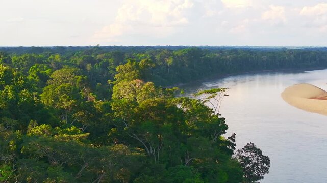 Telephoto aerial shot of the Tambopata River bending along the edge of the Amazon rainforest canopy in Madre de Dios Peru