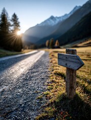 Scenic mountain path with direction sign at sunset in a tranquil valley