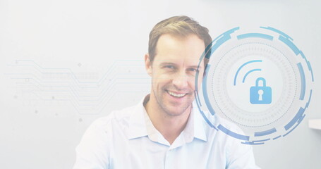 Smiling businessman wearing white shirt showing secure interface in office, with lock graphic