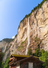 Vertical view of the Staubbachfall Waterfall in the Lauterbrunnen Valley, a famous tourist spot in Switzerland.