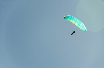 Paraglider flying high above the mountains with stunning panoramic views. Adventure and extreme sport.