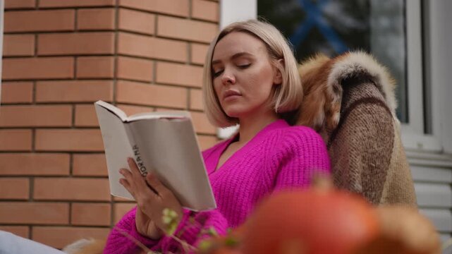 A woman currently enjoying a peaceful moment while reading a book in a cozy outdoor setting surrounded by nature