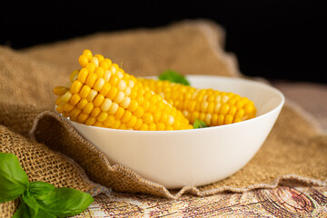 boiled corn with basil leaves in a bowl