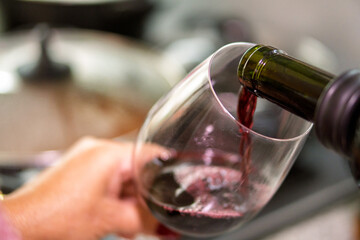 Pouring red wine into glass for lunch pairing