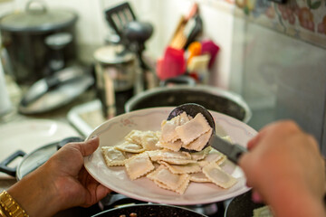 Chef serving fresh ravioli with meat sauce for lunch preparation