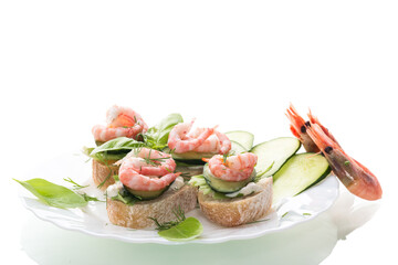 Small canapes with shrimps, salad and cucumbers on a white background