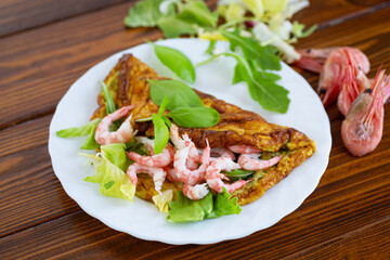 Homemade omelette with seafood on a dark wooden background