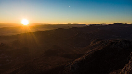 Golden hour sunlight illuminating a vast mountain range, creating a breathtaking panorama filled with nature's beauty and tranquility at dawn, inspires awe and peace in the morning sky