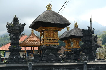 Balinese Family Temple of Black Stone with Gold Details, Thatched Roof, and Stone Animal Statue