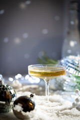 Christmas and New Year celebration with champagne. New Year holiday decorated table. Festive New Year champagne and silver baubles. Close up. Christmas greeting card with copy space.