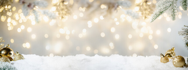 Christmas Holiday background with snow, fir tree and decorations with christmas light behind